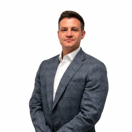 Professional business headshot of a man wearing a grey plaid blazer and white dress shirt against a clean white background.