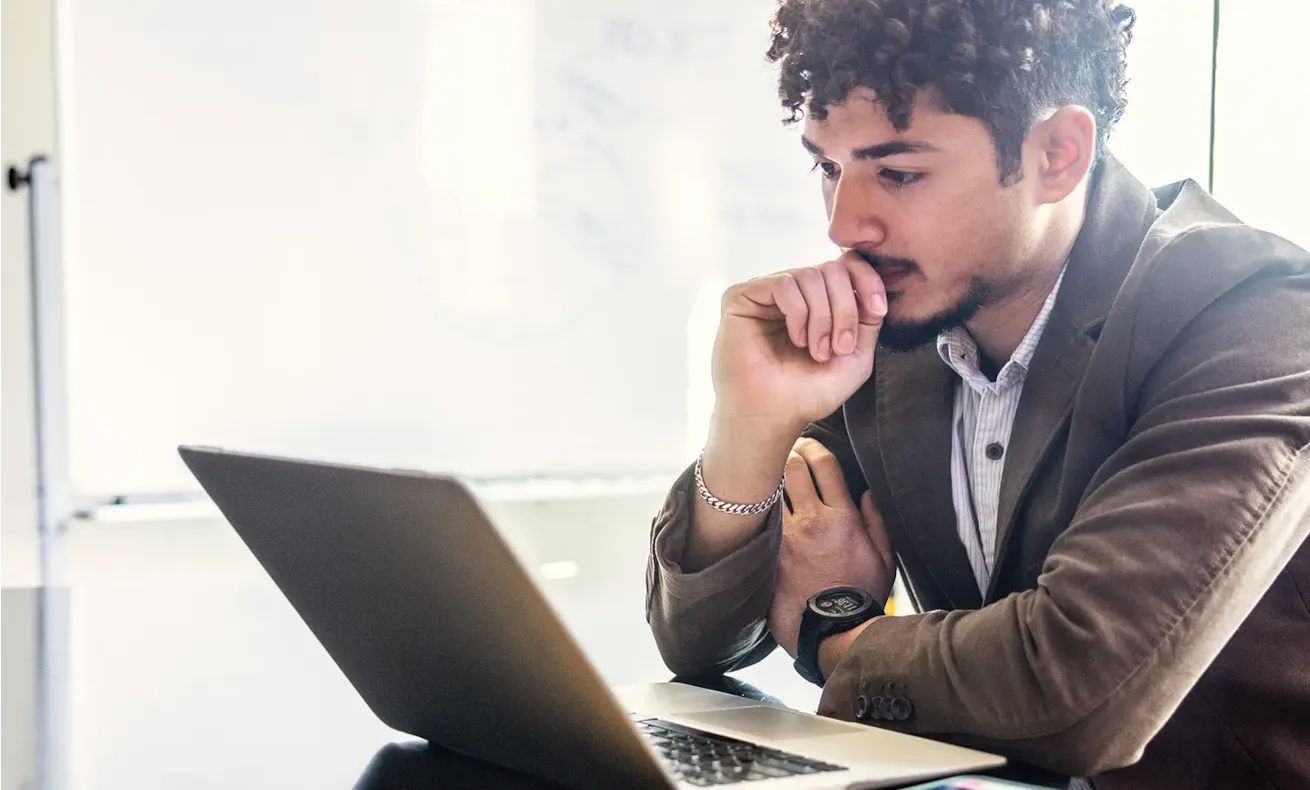 An engaged employee staring intently at a laptop computer screen.