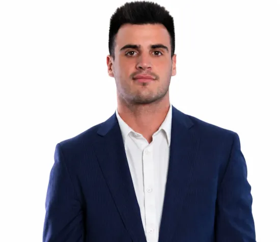 Smiling men with black hair wearing a white shirt and navy blue blazer on a white background.