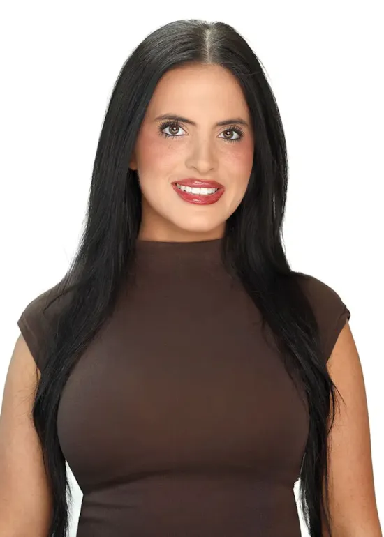 Woman with long black hair and brown top smiling at the camera against a plain white background.